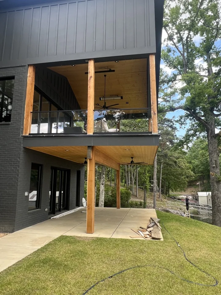 Pickwick’s timber balcony and covered lower terrace, with dark brick, tall glass doors and timber ceilings; finishing materials remain on site.