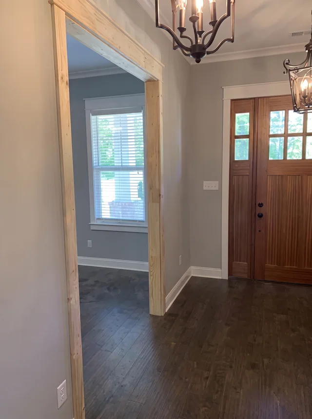 A timber front door and lantern fixture frame the entry hall.