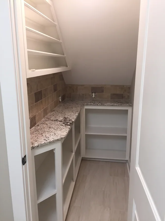 Open shelving meets a fitted stone counter in a compact closet.