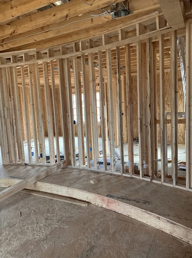 Exposed wall studs and ceiling joists define an interior before finishes.