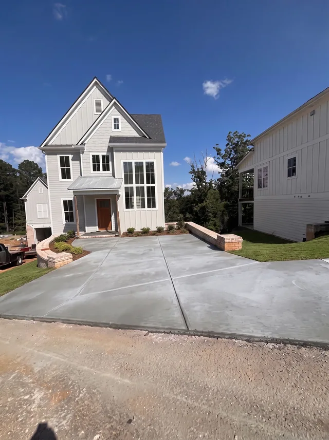 A steep-gabled white facade rises above a driveway.