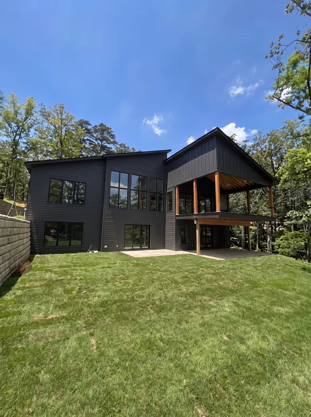 A dark multilevel facade and covered timber balcony.